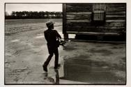 [Boy carrying wood to house]