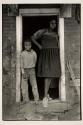[Young woman and boy standing in doorway]
