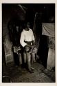 [Boy in room, standing with shoes in hand]