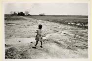 Girl looking out along a dirt road