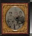 [Two soldiers seated with American flag]
