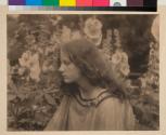 [Woman by hollyhocks]