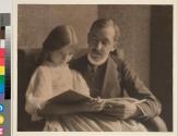[Man and young woman holding a book]