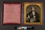 [Seated young man with books]