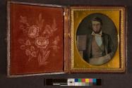 [Portrait of a man, holding sample book for cloth or wallpaper]