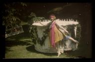 [Dancer in garden by birthday cake sculpture]
