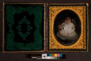 [Portrait of baby, adult arm holding child]