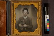 [Portrait of a boy, smoking cigar, holding a dog]