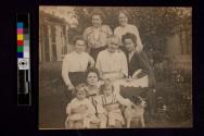 [Six women, two girls, and two dogs posed outside]