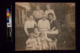 [Six women, two girls, and two dogs posed outside]
