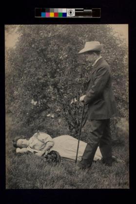 [Woman laying on ground and man standing with cane]