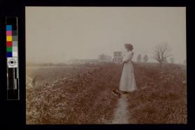 [Woman holding child looking at field]