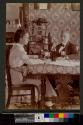 [Woman and man sitting at table with wine]