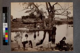 [Children standing in front of lake]