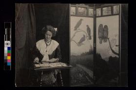[Woman sitting at desk playing cards]