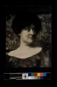 [Woman in front of floral background]
