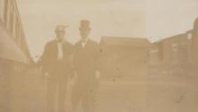 George Eastman and unidentified man beside train, Western Trip
