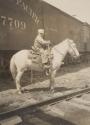 Boy on horse beside train, Western Trip
