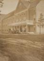 Horse drawn carriage beside large building, Western Trip