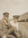 Walter Hubbell and Mary Mulligan in grass near train, Western Trip