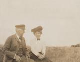 Walter Hubbell and Mary Mulligan in grass near train, Western Trip