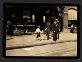 Candid shot of Newsie selling papers on street
