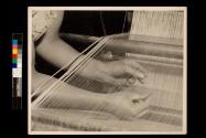 Through the Threads. Hands of a textile craftswoman in a large silk mill.