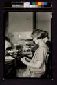 [Young woman at typewriter]