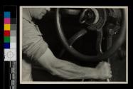 [At the control wheel...]
