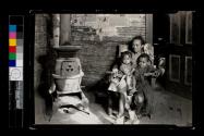 [Interior, mother and two children around pot-belly stove]