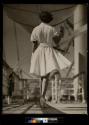 [Woman in white, walking away]