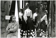[Woman and mannequin in a store window]