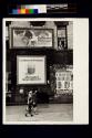[Woman and children walking along sidewalk]