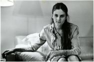[Woman seated on couch]