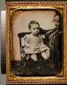 [Child seated in chair, mother positioned at edge of image]