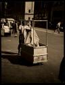 [Man pushing garment rack]
