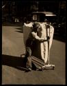 [Man pushing garment rack]
