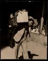[Man walking with package]