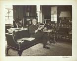 George Eastman reading in his sitting room