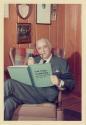 Harris Tuttle posing with pipe and retirement book