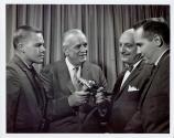 Harris Tuttle showing camera to three men