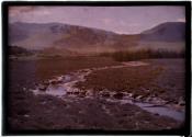 [Winding stream with mountains in background]