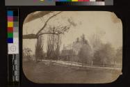 [Country stone house with trees and fence]