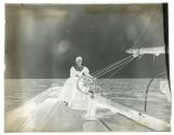 [Young woman at the helm of Watson Family yacht]
