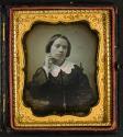 [Woman with hand at neck]