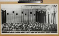 Group of men seated in an auditorium