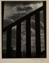 [City skyline seen through railing]
