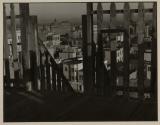 [City buildings through fence rails]