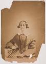 [Middle-aged woman, seated with arm on quilt-covered table]