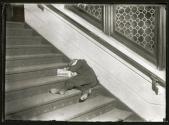 [Newsboy asleep on steps]